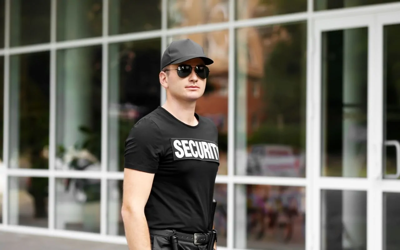 On-site security guard standing at a facility entrance during daytime