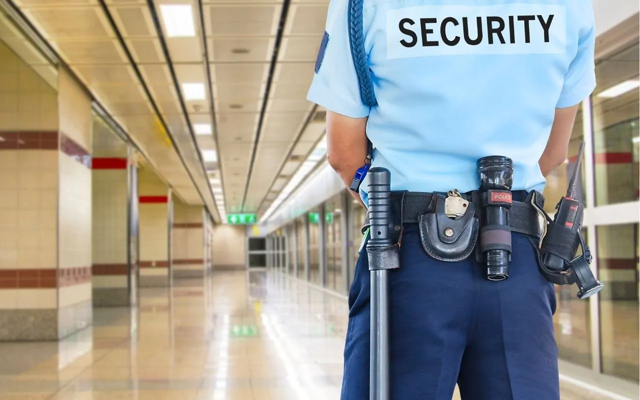 Uniformed corporate security guard standing in lobby of anoffice building
