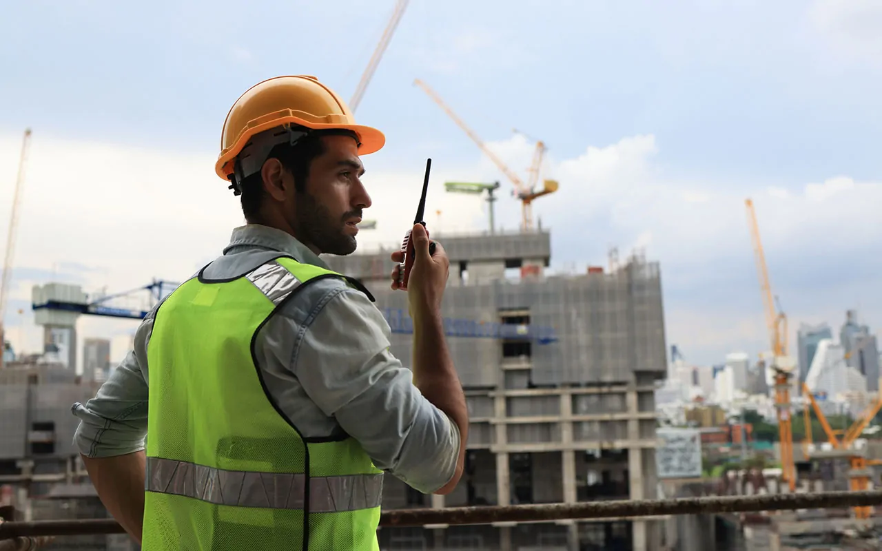 Security guard patrolling a fenced construction site in early development stage in Houston