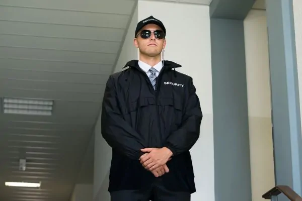 Armed security guard guarding the building entrance.