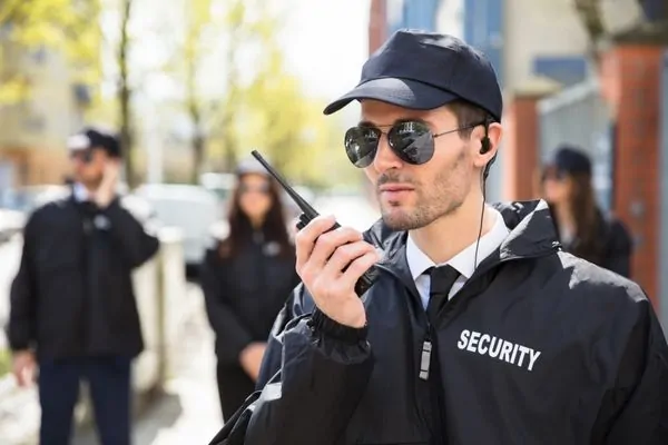 Security Guard on duty holding communication radio