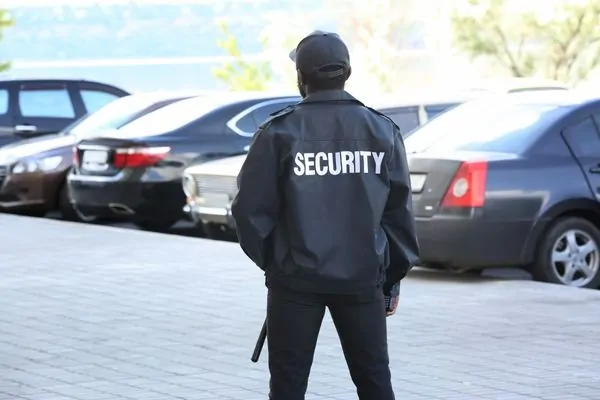 Uniformed security guard patrolling parking lot