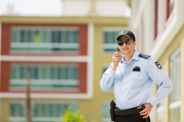 Security guard speaking through handheld radio device