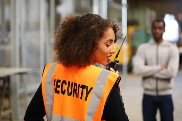 Warehouse security guard calling someone over the radio.