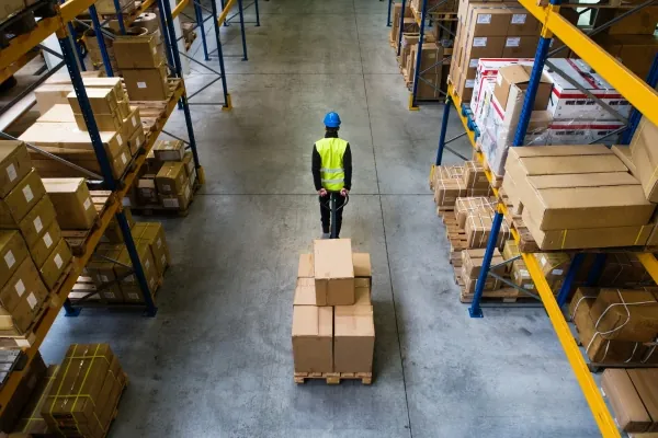 Warehouse worker moving heavy boxes to a new location.