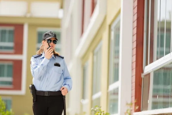 Unarmed security guard speaking into a radio.
