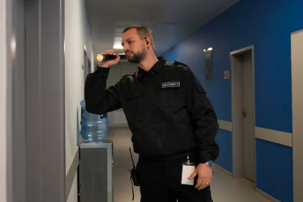 Security guard using a flashlight on patrol”