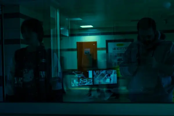 Two people reviewing store security camera footage on monitors in a dark room