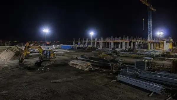 Floodlights illuminating a construction site at night 