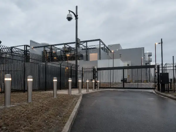 Layered perimeter security at a data center with fence, bollards, camera, and gate