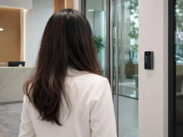 Facial recognition reader at a lit office lobby access door