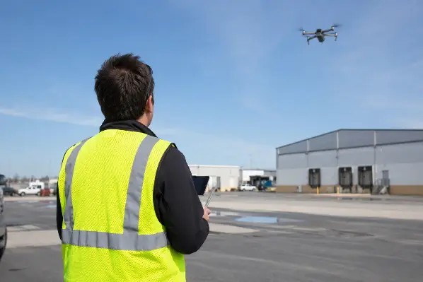 A drone operator keeping a security drone within line of sight during a flight