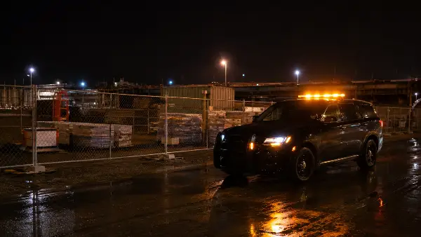 Security patrol vehicle with emergency lights responding at a Houston jobsite at night
