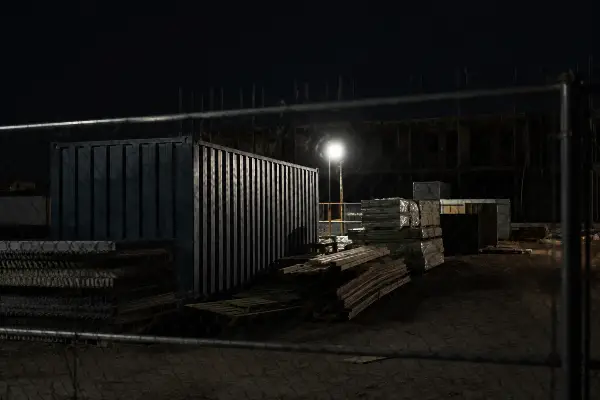 Construction site perimeter secured at night behind fencing in Houston