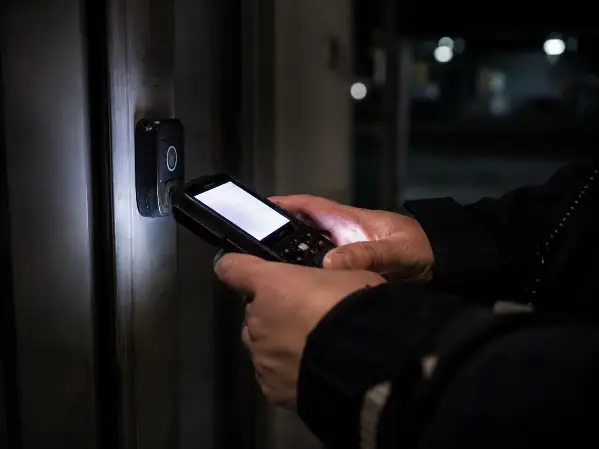 officer scanning a GPS guardtour checkpoint on night patrol