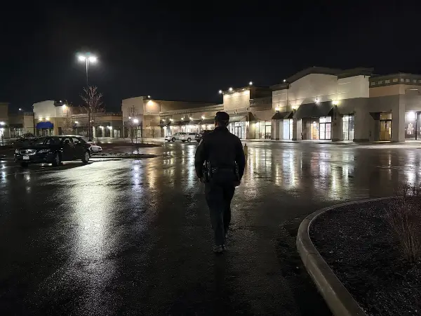 Night security guard patrolling a Houston retail shopping center parking lot