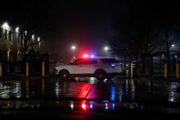 Marked security patrol vehicle with lights on deterring approach at a commercial gate