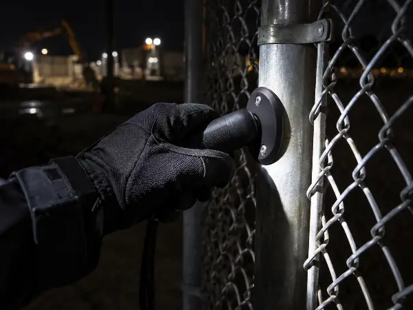 GPS guard tour checkpoint scan on a chain link fence at a construction site