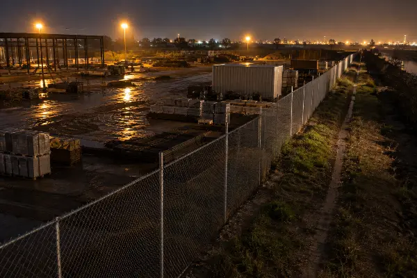 Fenced construction site perimeter at night where repeat activity is logged