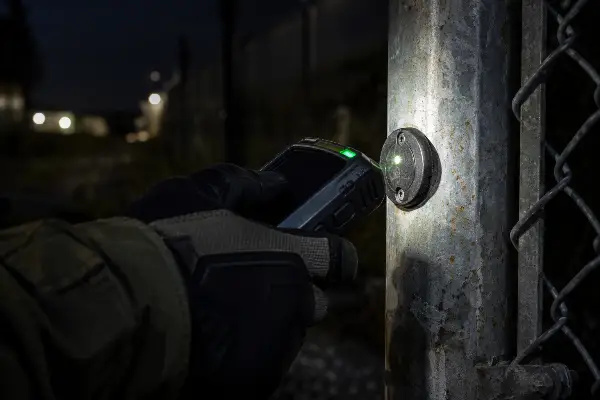 Security officer scanning a GPS guard tour checkpoint at a Houston job site