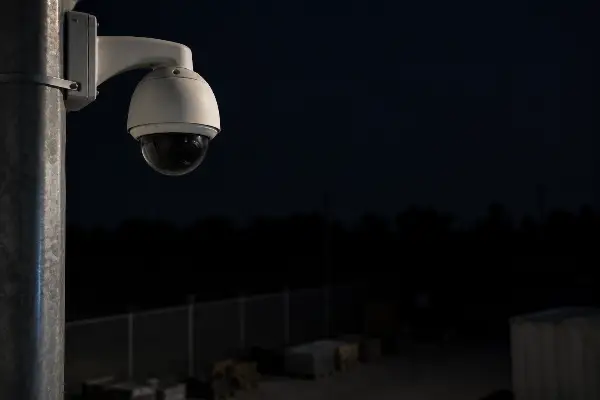 Security camera aimed at an unlit corner of a commercial yard at night