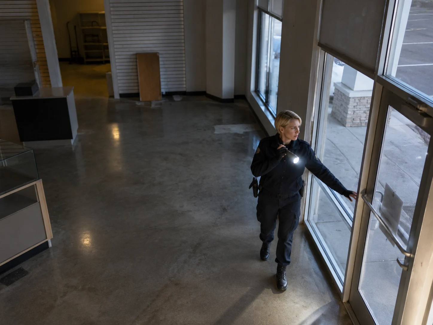 Temporary security guard inspecting doors and windows in a vacant retail space